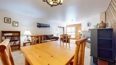 a living room with a wooden table and a couch at Aspen Creek Shared Amenities Near Hiking in Mammoth Lakes