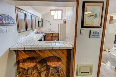 a kitchen with a counter with two stools in it at Aspen Creek #401 Year-Round Outdoor Activities in Mammoth Lakes