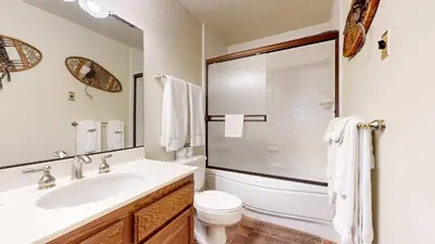 a bathroom with a sink and a toilet and a mirror at Walk to Mammoth Ski Lifts at Canyon Lodge Condo in Mammoth Lakes
