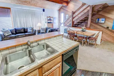 a kitchen with a sink and a living room at Canyon Ski & Racquet #1 Near Hike & Bike Trails in Mammoth Lakes