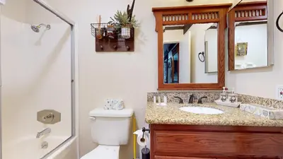 a bathroom with a toilet and a sink and a mirror at Canyon Ski Gateway Condo for 4 in Mammoth Lakes