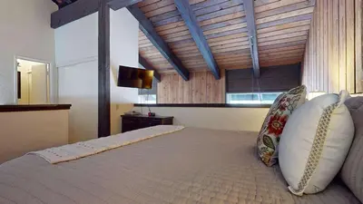 a bedroom with a large bed with a wooden ceiling at Canyon Ski Gateway Condo for 4 in Mammoth Lakes