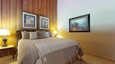 a bedroom with a bed and two pictures on the wall at Canyon Ski Gateway Condo for 4 in Mammoth Lakes