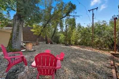 two red chairs and a table in a yard at Fire Escape Cabin-Southern Yosemite in Oakhurst