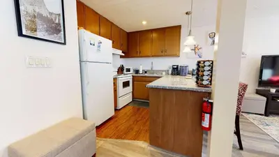 a kitchen with a white refrigerator and wooden cabinets at Sierra Manors In the Heart of Mammoth in Mammoth Lakes