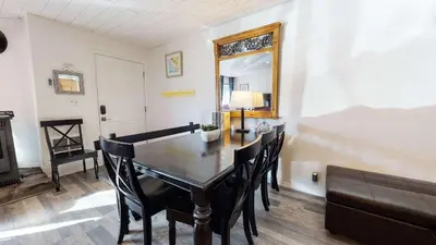 a dining room with a table and chairs and a mirror at Sierra Manors In the Heart of Mammoth in Mammoth Lakes