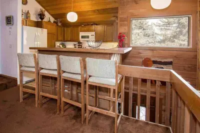 a kitchen with a bar with chairs and a counter at Snowcreek #059 Near Shuttle & Activities in Mammoth Lakes