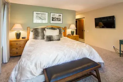 a bedroom with a large white bed with pillows at Snowcreek #566 Near Golf & Shuttle in Mammoth Lakes