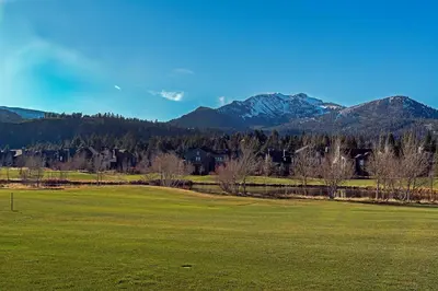 a green field with mountains in the background at Snowcreek #566 Near Golf & Shuttle in Mammoth Lakes