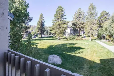 a yard with a fence with a bear on the grass at Snowcreek #566 Near Golf & Shuttle in Mammoth Lakes