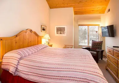 a bedroom with a large bed with a striped blanket at Snowcreek #630 Near Lakes & Golf in Mammoth Lakes