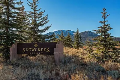 a sign in the middle of a field with trees at Snowcreek #630 Near Lakes & Golf in Mammoth Lakes