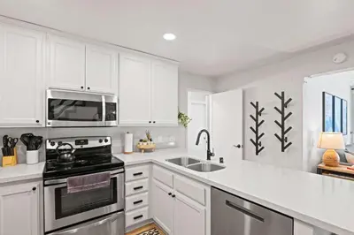 a white kitchen with a stove and a microwave at St Anton Getaway Shared BBQ Pool & Hot Tub in Mammoth Lakes