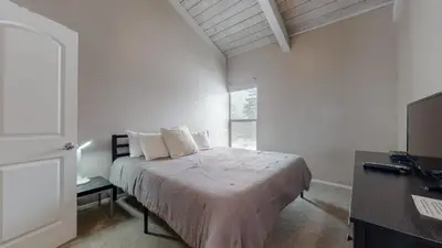 a bedroom with a bed with white sheets and a window at Chamonix #70 Near Yearly Outdoor Activities in Mammoth Lakes