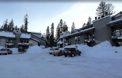 a parking lot covered in snow next to buildings at Chamonix Year-Round Fun with Shared Pool in Mammoth Lakes