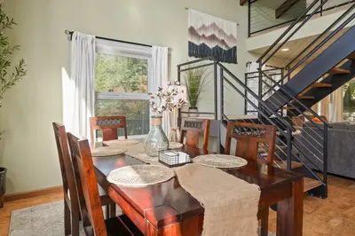 a dining room with a wooden table and chairs at Bearfoot Cabin 15 Min to Yosemite Gate! in Oakhurst