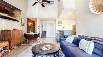a living room with a blue couch and a table at Chic 1 BDR Loft with Hot Tub Near Canyon Lodge in Mammoth Lakes