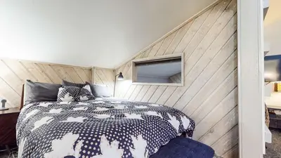 a bedroom with a bed with a wooden wall at Chic 1 BDR Loft with Hot Tub Near Canyon Lodge in Mammoth Lakes