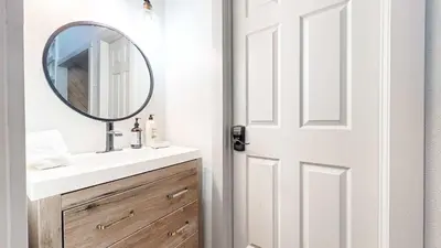 a bathroom with a sink and a mirror next to a door at Chic 1 BDR Loft with Hot Tub Near Canyon Lodge in Mammoth Lakes