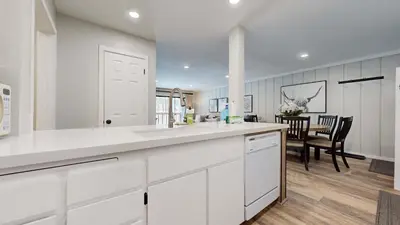 a kitchen with white cabinets and a dining room at Emerson Escape Incredible Moments at Mammoth in Mammoth Lakes