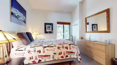 a bedroom with a bed and a dresser and a mirror at Escape to The Summit Pool & HT Next Door in Mammoth Lakes