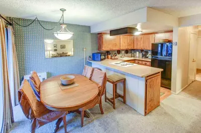 a kitchen with a wooden table and a dining room at Fireside Pool Access Hot Tub & More in Mammoth Lakes