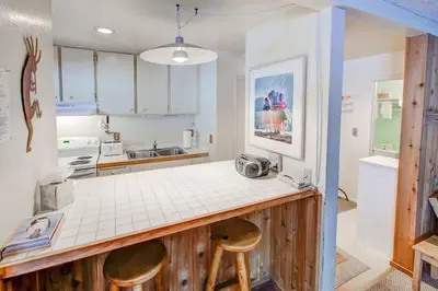 a kitchen with a counter and two stools in it at Studio with Amenities Walk to Village in Mammoth Lakes