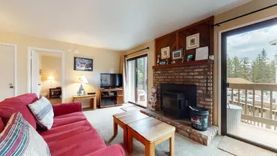 a living room with a red couch and a fireplace at Hidden Valley Homestead Near Hike Bike & More in Mammoth Lakes