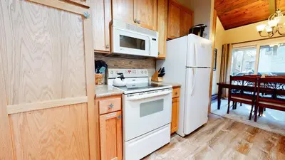 a kitchen with a white refrigerator and a stove at Horizons 4 Communal Rec Room & Pool in Mammoth Lakes