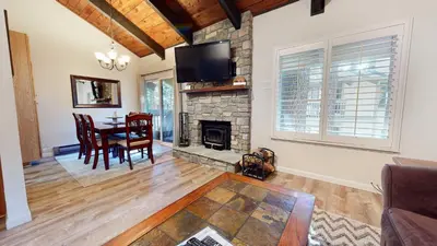 a living room with a table and a fireplace at Horizons 4 Communal Rec Room & Pool in Mammoth Lakes