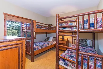 a room with three bunk beds and a kitchen at Stonegate #02 Luxe Condo with Foosball Table in Mammoth Lakes