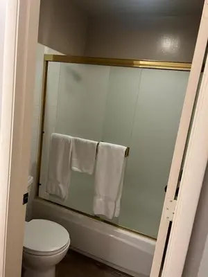 a bathroom with a shower with a toilet and towels at Sunshine Village #142 Close to Shops & Eats in Mammoth Lakes