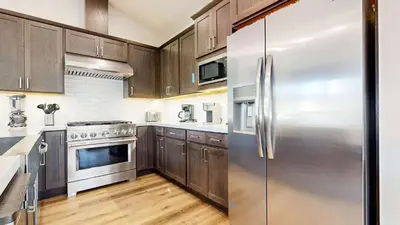 a kitchen with wooden cabinets and a stainless steel refrigerator at An Adventure of a Lifetime 3 BDR 5 Min to Skiing in Mammoth Lakes