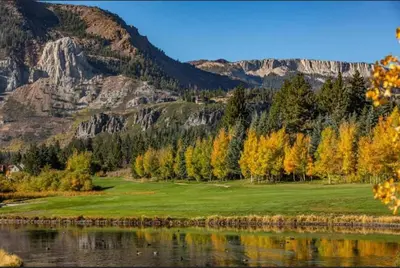 a golf course next to a lake and mountains at The Lodges by 8th Hole Year-Round Fun in Mammoth Lakes