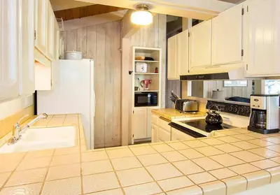 a kitchen with white cabinets and a white refrigerator at Villa De Los Pinos #33 Year-Round Activities in Mammoth Lakes
