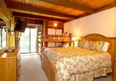 a bedroom with a bed and a television in a room at Villa De Los Pinos #33 Year-Round Activities in Mammoth Lakes