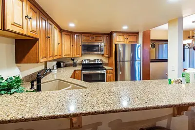 a kitchen with wooden cabinets and a stainless steel refrigerator at Horizons 4 - Excellent for Groups in Mammoth Lakes