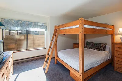 a bedroom with a bunk bed with a ladder at Horizons 4 - Pool & Hot Tub Access in Mammoth Lakes