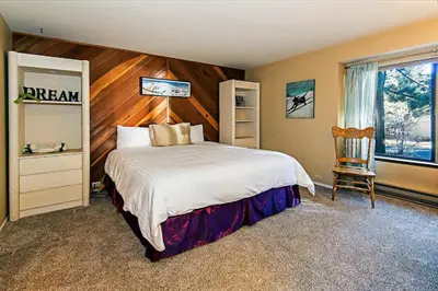 a bedroom with a bed and a wooden wall at Horizons 4 - Walk to Shops & Eateries in Mammoth Lakes