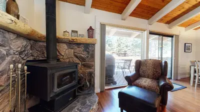 a living room with a wood stove and a chair at Villa De Los Pinos Year-Round Activities Nearby Shopping & Restaurants in Mammoth Lakes
