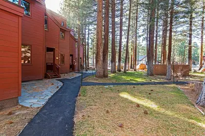 a driveway leading to a red house with trees at Winterset #01 Condo Near Year-Round Fun in Mammoth Lakes
