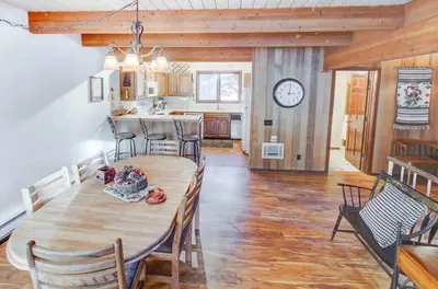 a dining room and kitchen with a table and a clock at Winterset #01 Condo Near Year-Round Fun in Mammoth Lakes