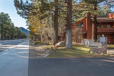 a building with a sign next to a street at Winterset #01 Condo Near Year-Round Fun in Mammoth Lakes