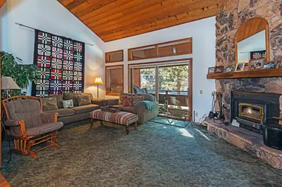 a living room with a stone fireplace in a house at Winterset #02 Shared Hot Tub & Pool in Mammoth Lakes