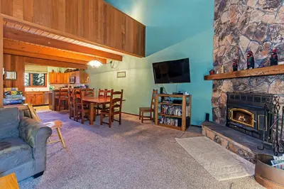 a living room with a fireplace and a table and chairs at Winterset #18 Shared Pool & Near Skiing in Mammoth Lakes