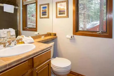 a bathroom with a sink and a toilet and a mirror at Winterset #28 Shared Hot Tub & Sauna in Mammoth Lakes