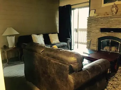 a living room with a leather couch and a fireplace at La Residence - Near Shuttle and Hike & Bike Trails in Mammoth Lakes