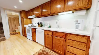 a kitchen with wooden cabinets and a white sink at La Residence - Shared Pool Hot Tub & More in Mammoth Lakes