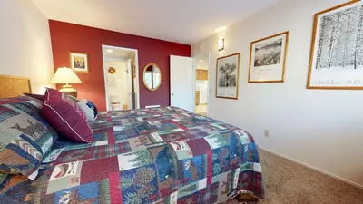 a bedroom with a bed with a colorful quilt at La Residence - Shared Pool Hot Tub & More in Mammoth Lakes