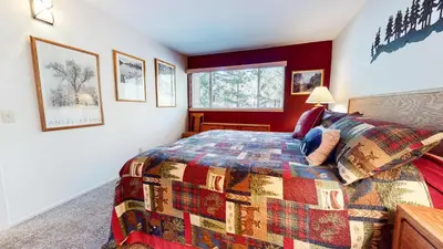 a bedroom with a bed with a colorful quilt at La Residence - Shared Pool Hot Tub & More in Mammoth Lakes